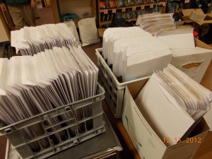 Packets are stuffed with schedules, sorted and packed for the meeting