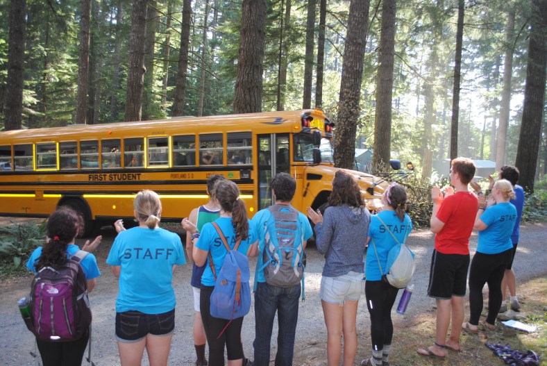 Camp Howard Summer Staff sing to departing campers as the last bus rolls out of camp for the summer camping program.