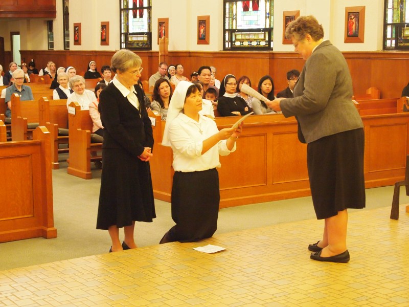 Sister Anna Nguyen receives the constitution of the Sisters of St. Mary of Oregon from Sister Charlene Herinckx, the religious leader of the Sisters.