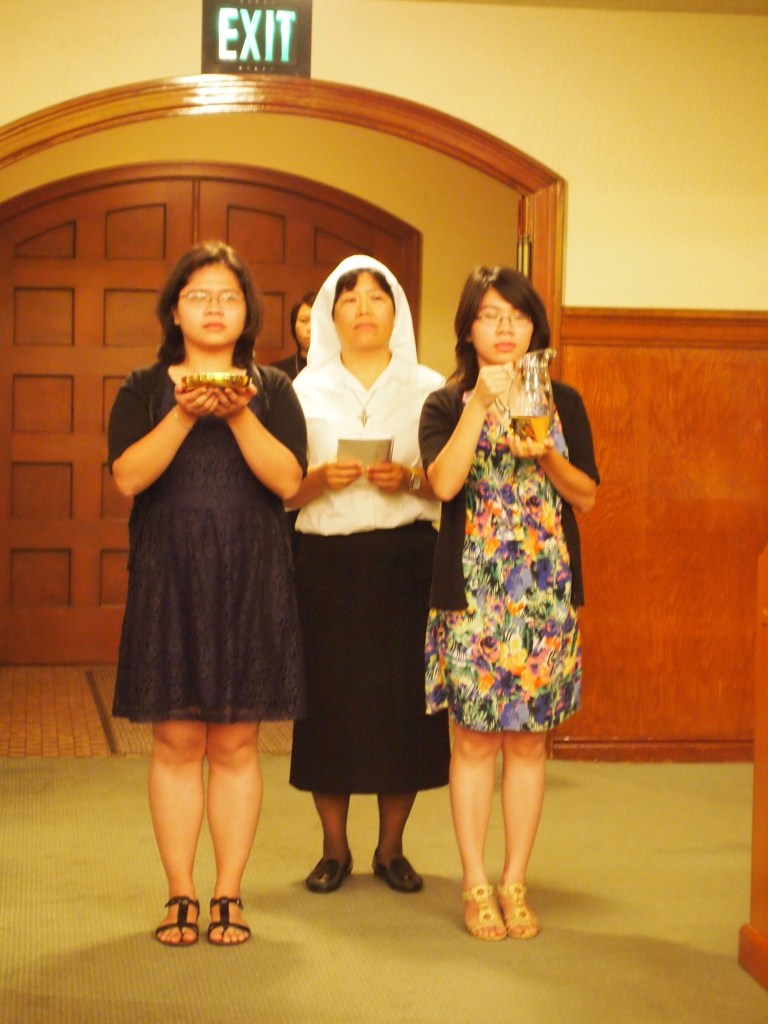 Sister Anna Nguyen and relatives bring gifts to the altar