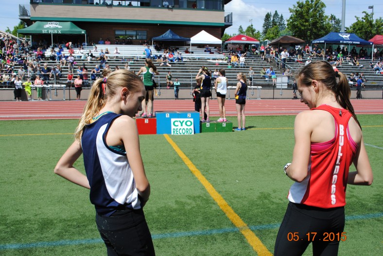 Waiting to be called to the awards stand, Elizabeth Rinck (St. Matthew) and Makenna Schumacher (St. Thomas More) ponder the moment