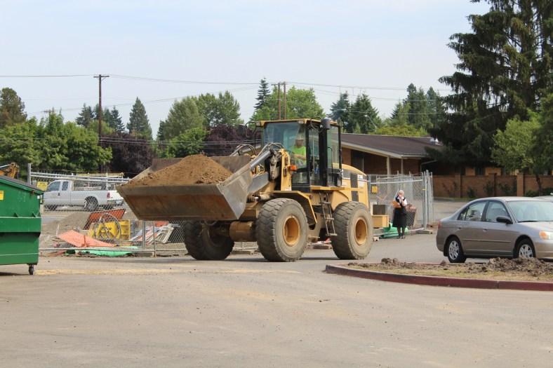 moving dirt around to make room for a new location for the dumpster near the new parking lot.